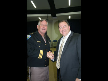 two men at the Medal of Valor ceremony shaking hands and smiling at the camera