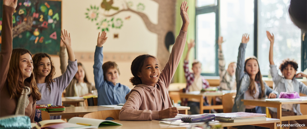 Classroom with children raising hands