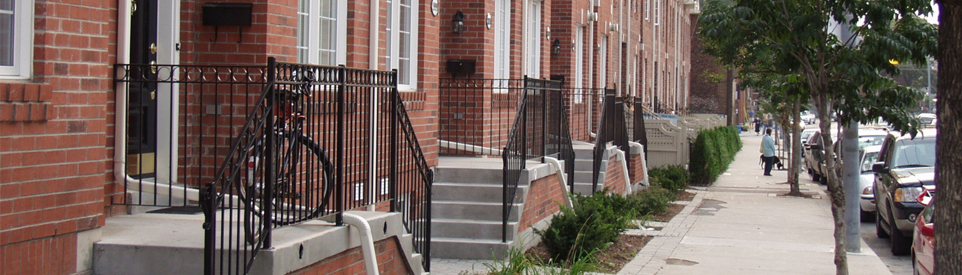 Street scene showing brownstones, sidewalk, and cars